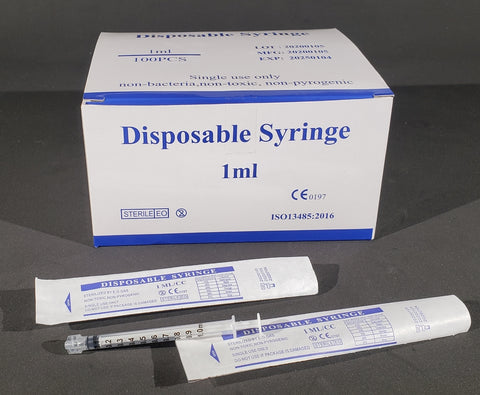 tube of disposable syringe next to a box