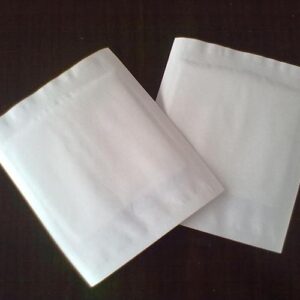 two white napkins sitting on top of a table